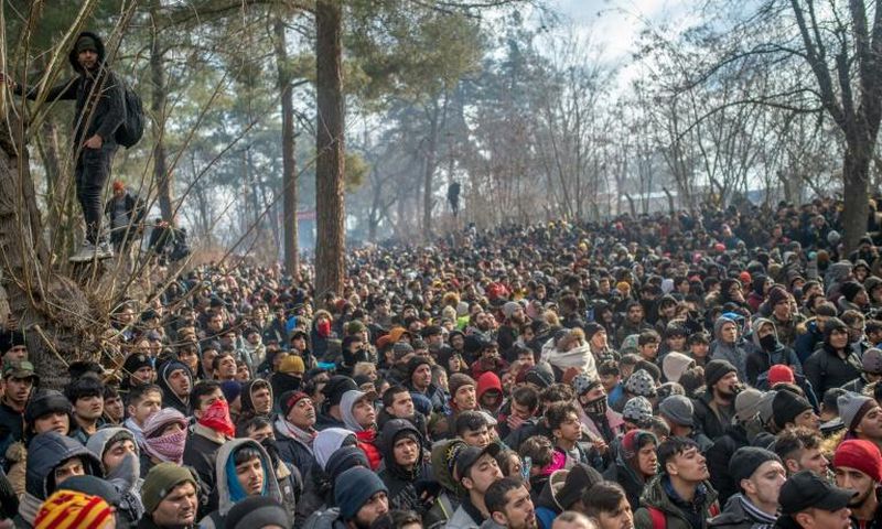Some of the thousands of migrants gathered at the Turkish side of the border