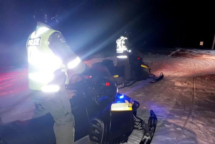 Police use snowmoblies during a search and rescue operations after a Canadian guide died and five French tourists went missing when their snowmobiles plunged through ice into the freezing water