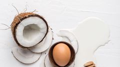 Coconut, egg and fresh milk on a white background, top view