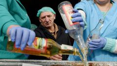 A supervisor looks on as workers empty bottles of the adulterated vodka in the town of Vynnyky, western Ukraine