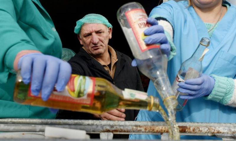 A supervisor looks on as workers empty bottles of the adulterated vodka in the town of Vynnyky, western Ukraine