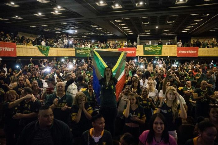 A woman (C) holds a South African flag as a crowd watches the Rugby World Cup final at a Johannesburg theme park last Saturday