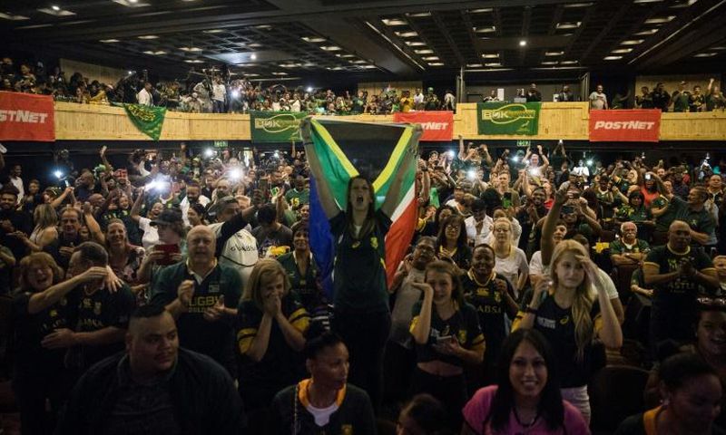 A woman (C) holds a South African flag as a crowd watches the Rugby World Cup final at a Johannesburg theme park last Saturday