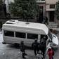 Police escort a detained man into a van after a raid on a "squat" in Koukaki, a central district of Athens in December 2019