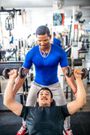 Personal trainer explaining how to exercise with dumbbells at the gym