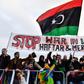 Protesters hold a banner reading "Stop war in Libya, Haftar and mercenaries" during a protest near the chancellery during the Peace summit on Libya at the Chancellery in Berlin on January 19, 2020