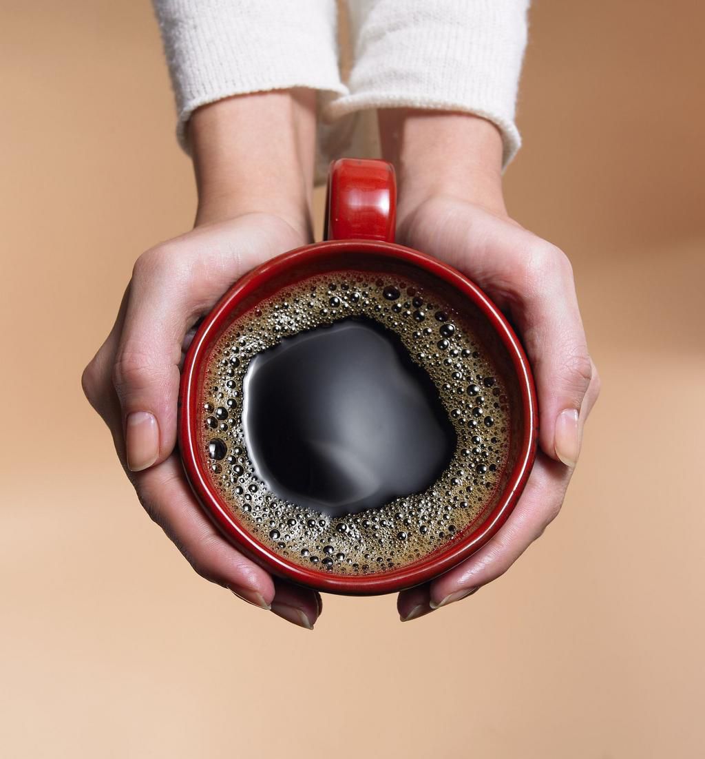 &quot;Woman holding coffee cup, close-up, overhead view&quot;