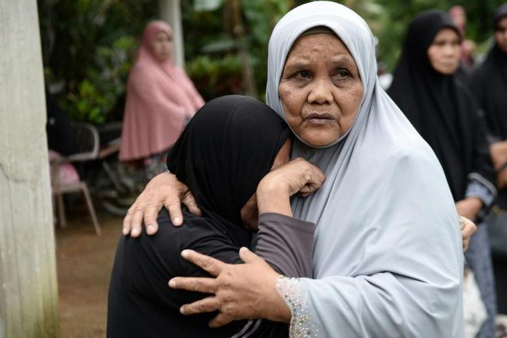 Relatives of three Thai men killed after being mistaken for militants comfort each other while waiting for the bodies of their loved ones to be released