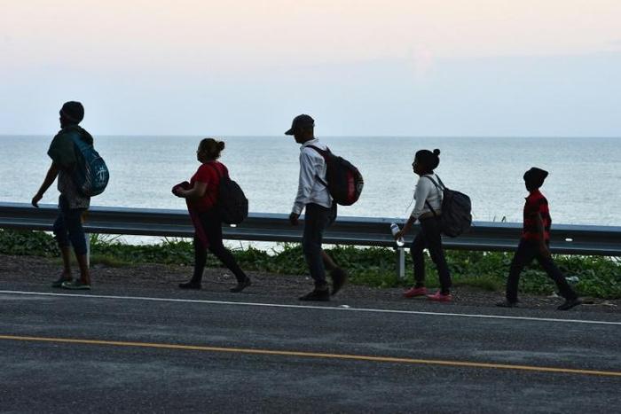 Honduran migrants in the northern coastal town of Omoa make their way to San Pedro Sula to join a caravan heading to the southern US border