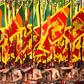 Sri Lankan military personnel in traditional dress holding national flags during Sri Lanka's 72nd Independence Day celebrations in Colombo