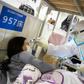 A health worker checks the temperature of a patient at a hospital in Wuhan