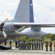 Chilean military personnel stand by an Air Force plane as they wait to unload human remains found during the search for the C-130 Hercules transport plane that crashed in the sea on its way to Antarctica