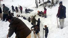 Local residents search for victims of an avalanche that hit the  Neelum Valley in Pakistan-administered Kashmir