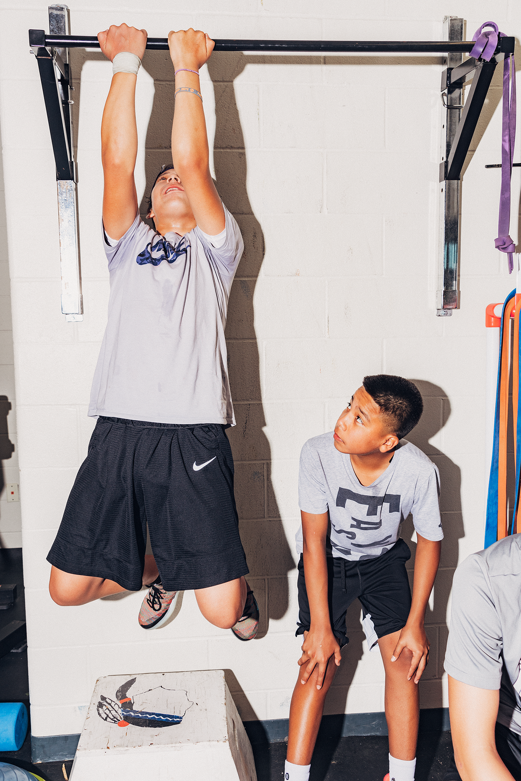 <strong>WINNEBAGO INDIANS TEAMMATES</strong> Zaiden Bernie and Zakodi BlackSpottedHorse work out in the high school weight room ahead of a scrimmage in Winnebago, Nebraska on July 16, 2019.