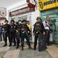 An official told journalists that a security guard was holding up to 30 people in an administrative office and had shot at least one person