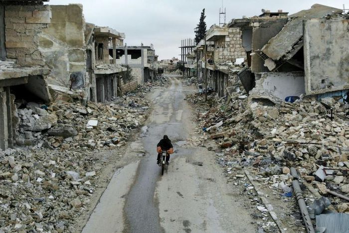 A man rides a motorbike through the almost-deserted town of Kafranbel on February 15, just days before its capture by the regime