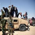 Afghan Taliban militants and residents stand on an Afghan National Army armoured Humvee as they celebrate a ceasefire in Kandahar province
