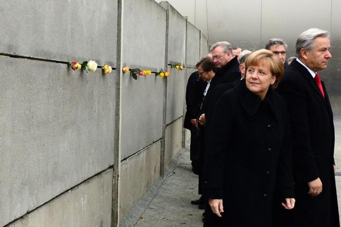 German Chancellor Angela Merkel leaving a tribute in a preserved segment of the Berlin Wall in 2014