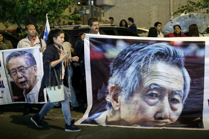 Supporters of Peruvian ex-president Alberto Fujimori (pictured October 2018) hold up posters of the former leader, who has been hospitalized for neurological and pulmonary issues