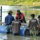 Australian crocodile wranglers  Matthew Nicolas Wright (right) and Chris Wilson (left) directing the lndonesian team in setting the trap in the river in Palu