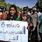 A woman holds up a sign reading in Arabic: "The people demand retribution for the martyrs", during a demonstration in the centre of Sudan's capital