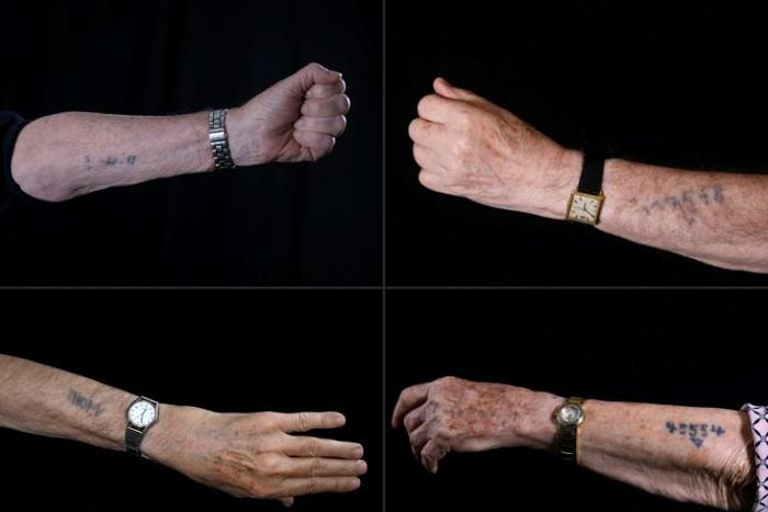 Holocaust survivors show Auschwitz prison numbers on their arms