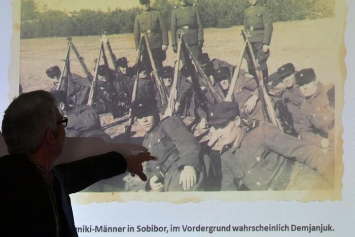 A staff member of the Topography of Terror archive points at a historical photograph allegedly showing convicted Nazi guard John Demjanjuk at the Sobibor camp