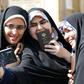 Iranian voters pose for a selfie during parliamentary elections at the Shah Abdul Azim shrine on the southern outskirts of Tehran on Friday