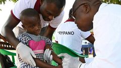 A health worker takes blood from a child in the Ivorian village of Paanenefla - The sample will be tested for sleeping sickness