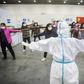 A medical staffer leads patients who have displayed mild symptoms of the COVID-19 illness in group exercises at a hospital in Wuhan, the epicenter of the global outbreak