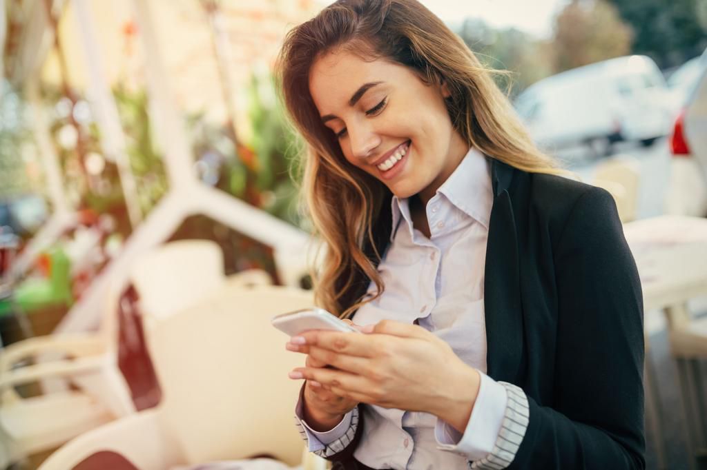 Happy businesswoman using phone