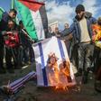 Palestinians angry at controversial peace proposals unveiled by US President Donald Trump burn an Israeli flag during a protest in the Gaza Strip city of Khan Yunis