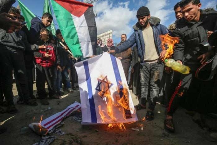 Palestinians angry at controversial peace proposals unveiled by US President Donald Trump burn an Israeli flag during a protest in the Gaza Strip city of Khan Yunis