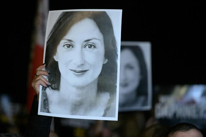 Protesters (pictured November 2019) hold pictures of late journalist Daphne Caruana Galizia, who was investigating allegations of bribes to public officials when she was killed by a car bomb