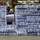 A woman wearing a protective face mask walks past stacks of toilet paper for sale in the Tsuen Wan district of Hong Kong