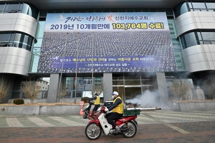 South Korean health officials spray disinfectant in front of the Daegu branch of the Shincheonji Church of Jesus in an attempt to combat the COVID-19 coronavirus outbreak