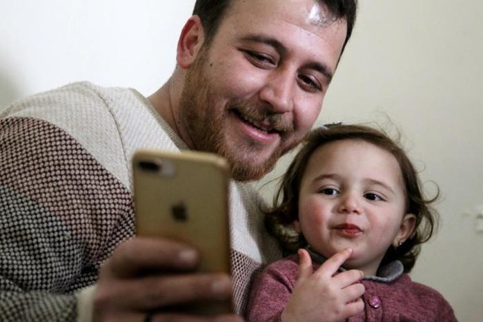 Syrian father Abdullah al-Mohammed with his three-year-old daughter Salwa. A video in which she laughs every time an explosion goes off was widely shared on social media as a heartening but grim reminder of Idlib residents' daily lives