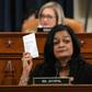 Democratic lawmaker Pramila Jayapal holds up a copy of the Constitution as she votes to impeach President Donald Trump