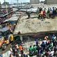 Onlookers swarmed the twisted ruins of the six-floor building, using their bare hands to pull out injured people