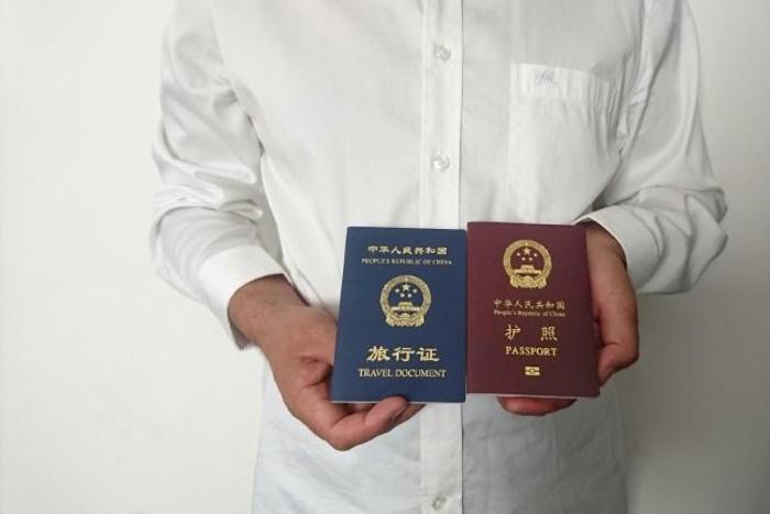 An unidentified Chinese Uighur man in the city of Medina holds his expired Chinese passport (red) and a one-way travel document (blue) issued in its place by the Chinese mission in Saudi Arabia