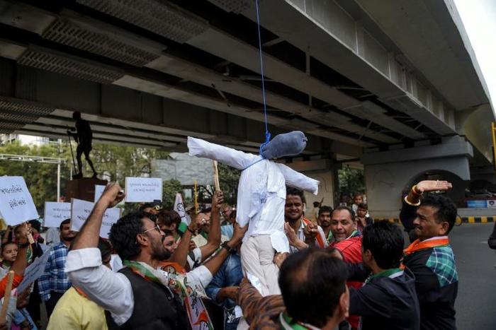 Demonstrators from the National Congress Party hang and beat a dummy of a rapist as they protest against sexual violence