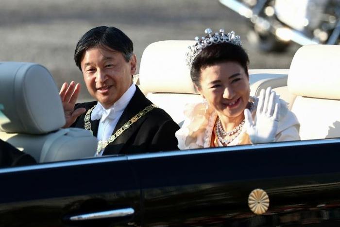 Japan’s Emperor Naruhito  and Empress Masako wave during their royal parade in Tokyo