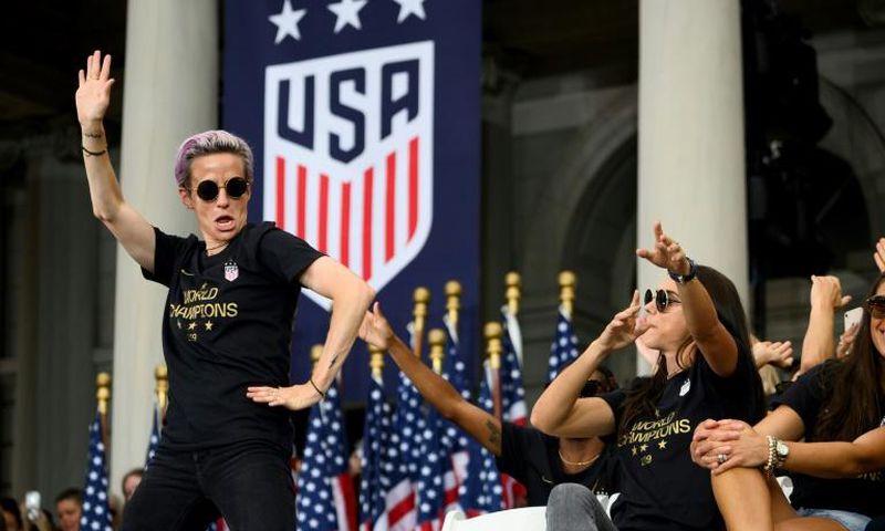 US women's soccer star Megan Rapinoe, left, and her teammates won a court ruling Friday in their fight for equal pay from the US Soccer Federation