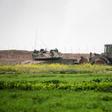 An Israeli tank and a bulldozer are seen along the border fence between Israel and the Gaza Strip where the army says troops shot dead a Palestinian suspected of placing a bomb near the barrier