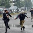 A policeman chases a lawyer following the clash at a Lahore cardiac hospital