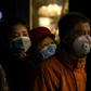 People wearing protective facemasks queue for food in Shanghai