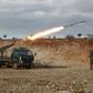 Syrian rebel fighters fire a rocket in northwestern Syria where battles with government forces have intensified in recent weeks