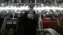 A city council worker in protective clothing disinfects a bus in Tehran as part of government efforts to control a novel coronavirus outbreak that has now killed 19 people