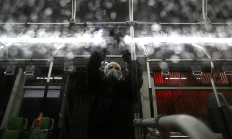 A city council worker in protective clothing disinfects a bus in Tehran as part of government efforts to control a novel coronavirus outbreak that has now killed 19 people