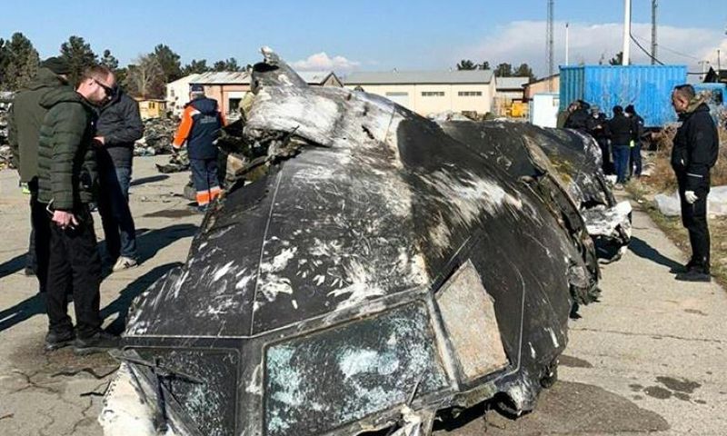 People analyze the fragments and remains of the Ukraine International Airlines plane that crashed outside Tehran